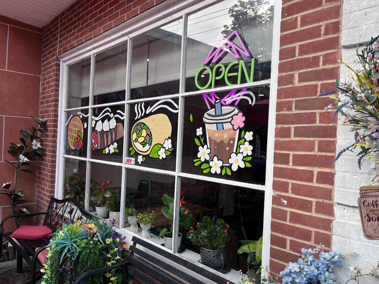 Funcle’s Café storefront window with an open sign and hand-painted food and drink artwork.